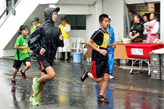 大雨の中を走る小学生ランナー